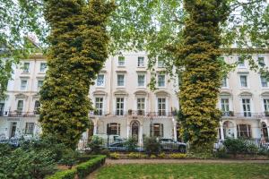 deux grands arbres devant un bâtiment blanc dans l'établissement Shakespeare Hotel, à Londres