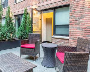 a patio with wicker chairs and tables and a building at The Paul Hotel NYC-Chelsea, Ascend Hotel Collection in New York