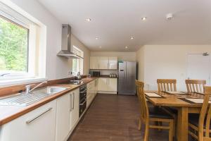 a kitchen with a wooden table and a kitchen with a dining table at Hendy - First Floor Apartment in Moelfre