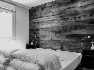 1 dormitorio con 2 camas y pared de madera en Romil26 By Vigovacaciones, en Vigo