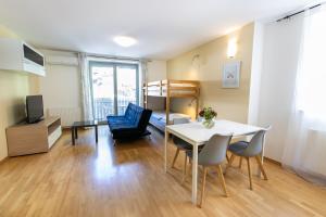 a living room with a table and chairs and a bed at Apartment Muznik in Bled