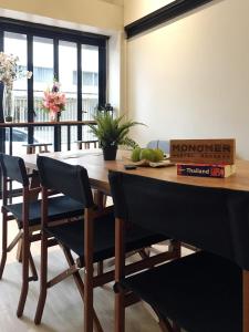 a dining room with a wooden table and chairs at Monomer Hostel Bangkok in Bangkok