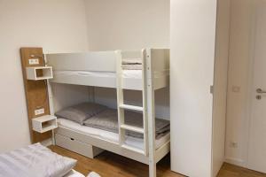 a white bunk bed with a ladder in a room at Apartment I , Netflix, Küche und Gym in Reken