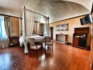 a room with a table and chairs and a bed at Abbazia delle Sorelle in Novello