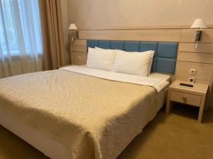 a bedroom with a large bed with a blue headboard at Boutique Hotel Voskresensky in Istra