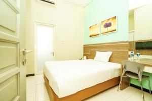 A bed or beds in a room at Ardhya Guesthouse Syariah by ecommerceloka