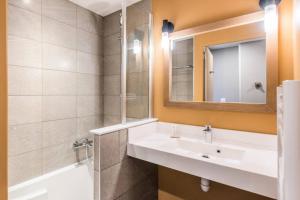 a bathroom with a sink and a mirror and a tub at Residence Arietis - maeva Home in Avoriaz +9 photos
