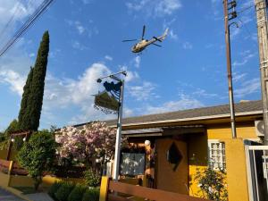 a helicopter flying over a house with a sign at Pousada Casa da Serra in Urubici