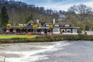 a large house with a river in front of it at Fisherman's Cot, Tiverton by Marston's Inns in Tiverton