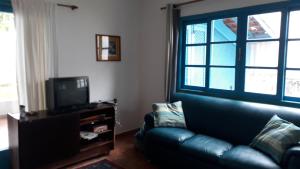 a living room with a couch and a tv at Casa perto da praia in Itanhaém