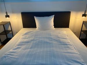 a bed with a white pillow on top of it at City Apartments Kaiserslautern in Kaiserslautern