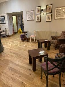 sala de estar con mesas, sofás y sillas en The Plough, en Alnwick