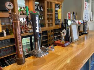 a bar with bottles of alcohol on a counter at The Plough in Alnwick