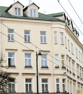a large white building with windows on a street at Kosmopolita Rooms in Krakow