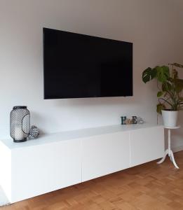 a white entertainment center with a flat screen tv on a wall at Helle, moderne Ferienwohnung am Waldrand in Prüm für max 4 Personen in Prüm