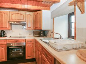 a kitchen with wooden cabinets and a sink at Viola Cottage in Fraserburgh