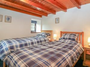 two twin beds in a room with wooden ceilings at Viola Cottage in Fraserburgh