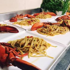 a bunch of plates of food with pasta and lobster at Hotel Alex in Florence