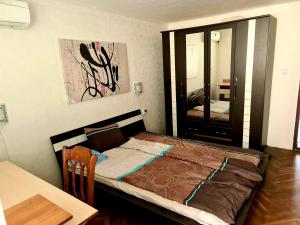 1 dormitorio con cama, mesa y espejo en три стаен лукс апартамент, en Razgrad