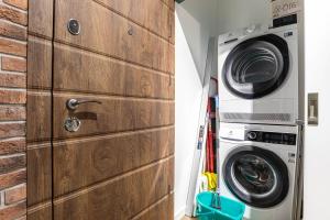 un gran armario de madera junto a una lavadora en Luxury Urban Lofts Across Baseina 5а & Arena, en Kiev