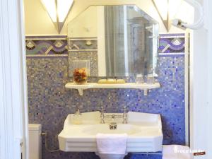 a bathroom with a white sink and a mirror at La Maison Rouge Brocéliande in Montauban-de-Bretagne