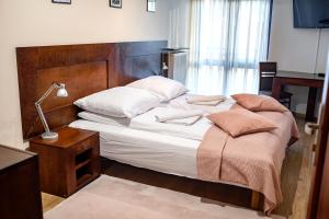 um quarto com uma cama com um candeeiro e uma mesa em Apartamenty Sun & Snow Centrum Krynica Zdrój em Krynica-Zdrój