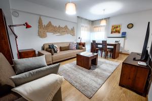 sala de estar con sofá y mesa en Apartamenty Sun & Snow Centrum Krynica Zdrój, en Krynica-Zdrój