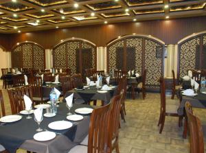 a restaurant with tables and chairs in a room at Hotel de Raj Sialkot in Sialkot