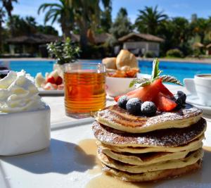 a stack of pancakes with fruit on a table at Hotel Costa dei Fiori in Santa Margherita di Pula