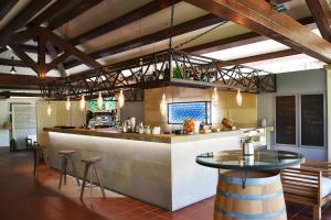 a bar in a restaurant with a counter and stools at Hotel Costa dei Fiori in Santa Margherita di Pula