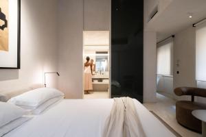 una camera con letto bianco e bagno di Hotel Scenario a Roma