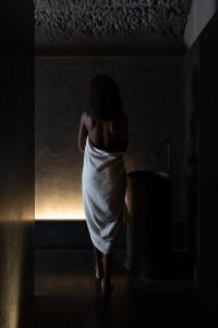a woman in a towel walking into a bathroom at Hotel Scenario in Rome