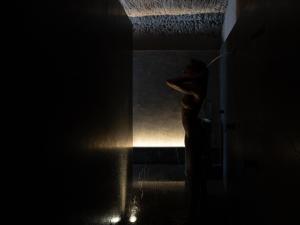 a woman is standing in a dark room at Hotel Scenario in Rome