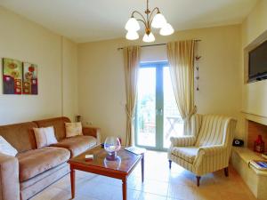 sala de estar con sofá y silla en Villa Marianna, en Lourdata
