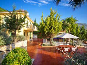 a house with a patio with a table and an umbrella at Villa Atlantis in Katelios