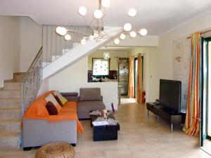 a living room with a couch and a tv at Villa Yianna in Karavádhos