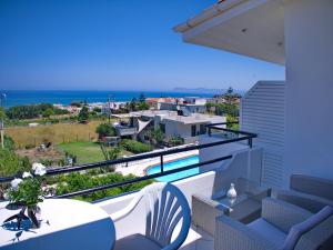 balcón con mesa, sillas y vistas al océano en Rouladina Apartments, en Stalós