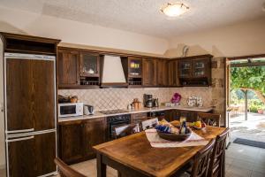 eine Küche mit Holzschränken und einem Holztisch in der Unterkunft Villa Faye in Vryses