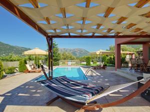 un patio con una hamaca y una piscina en Villa Nireaus, en Chaliotata