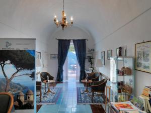 a room with a chandelier and a room with tables and chairs at Hotel Parsifal - Antico Convento del 1288 in Ravello