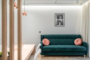 a green couch in a living room with a table at RentPlanet - Apartamenty Jagiełły in Wrocław