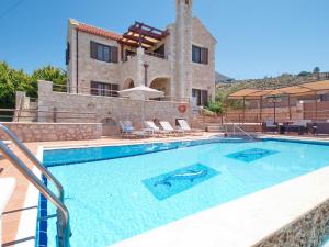 a swimming pool in front of a house at Villa Zara in Almyrida