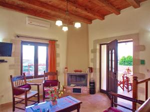 a living room with a fireplace and a table and chairs at Villa Zara in Almyrida