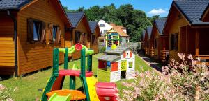een rij huizen met speeltoestellen in het gras bij Wisełka Domki Letniskowe NEMO in Wisełka