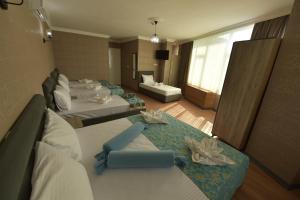 イスタンブールにあるOmega Luxx Hotelのベッド4台とソファが備わるホテルルームです。