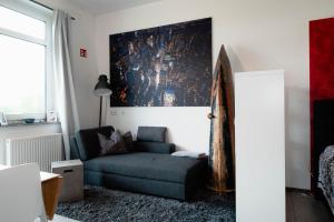 a living room with a couch and a painting on the wall at Businessapart Stuttgart in Gäufelden
