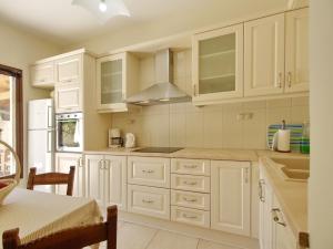 una cocina blanca con armarios blancos y fregadero en Villa Argiro Plaka Crete, en Plaka