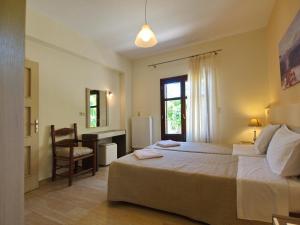 a bedroom with a bed and a desk and a chair at Villa Argiro Plaka Crete in Plaka +32 photos