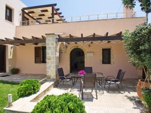 een patio met een tafel en stoelen voor een huis bij Villa Argiro Plaka Crete in Plaka