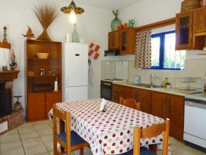 a kitchen with a table and a white refrigerator at Maros Spitaki in Varípetron